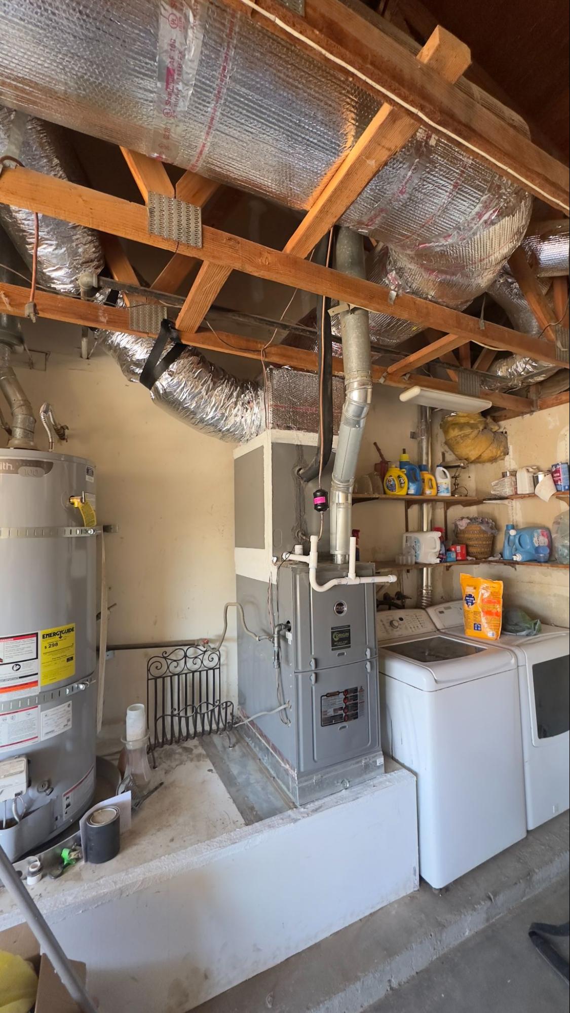 Attic space showing insulated ductwork, furnace, and water heater ahead of an AC installation in Palmdale